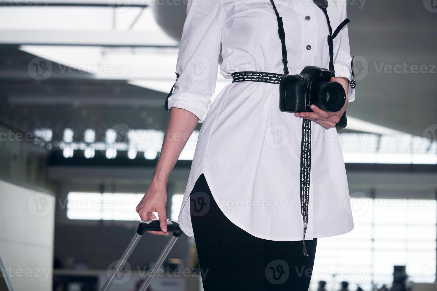 femme voyageur avec une valise et une caméra dans le bâtiment de le aéroport ou train station photo