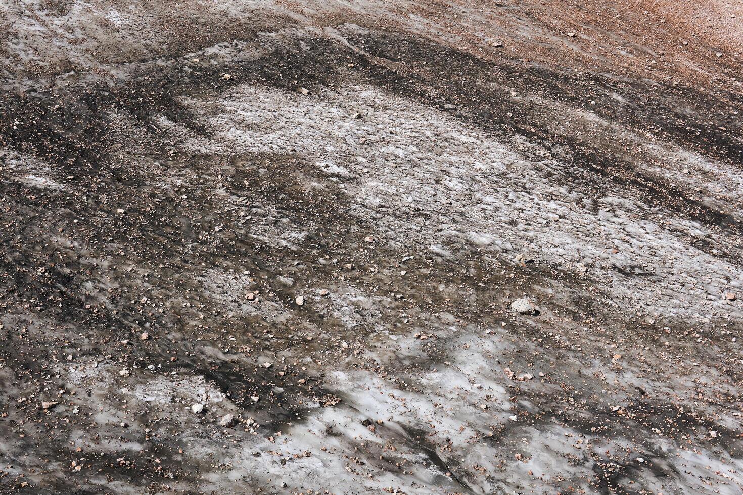 surface de une fusion Montagne glacier couvert avec des pierres et décombres photo