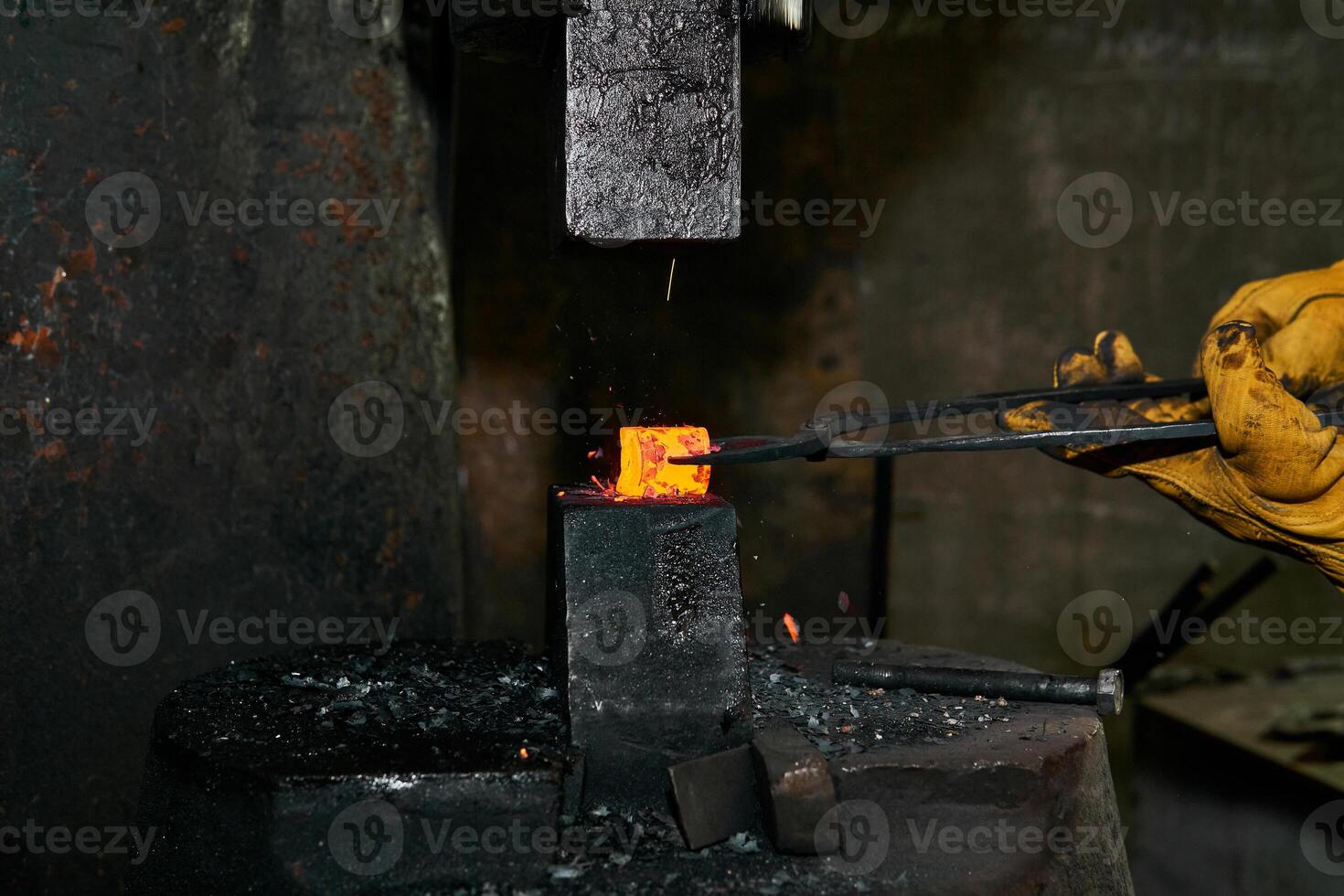 femelle mains processus une rouge chaud pièce avec une Puissance marteau photo