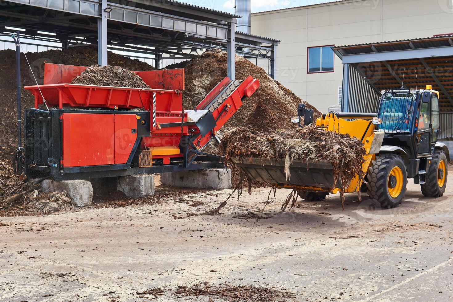 seau chargeur charges arbre écorce dans un industriel déchiqueteuse photo