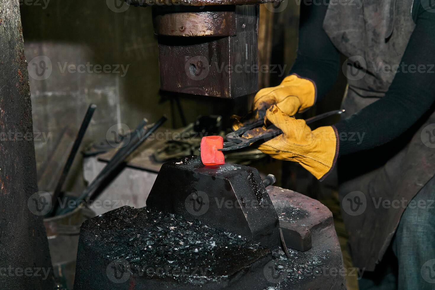 femelle mains processus une rouge chaud pièce avec une Puissance marteau photo