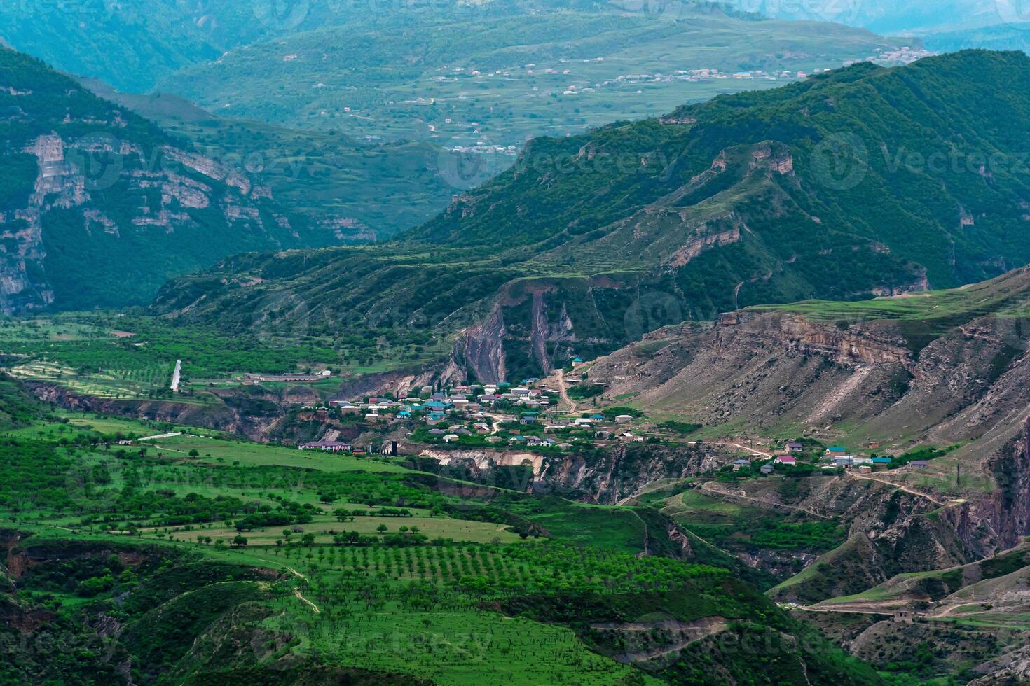 aérien vue de une village dans une Montagne vallée parmi jardins et des champs photo