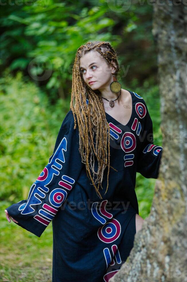 magnifique fille avec des dreadlocks, habillé hippie style, pose en plein air. photo
