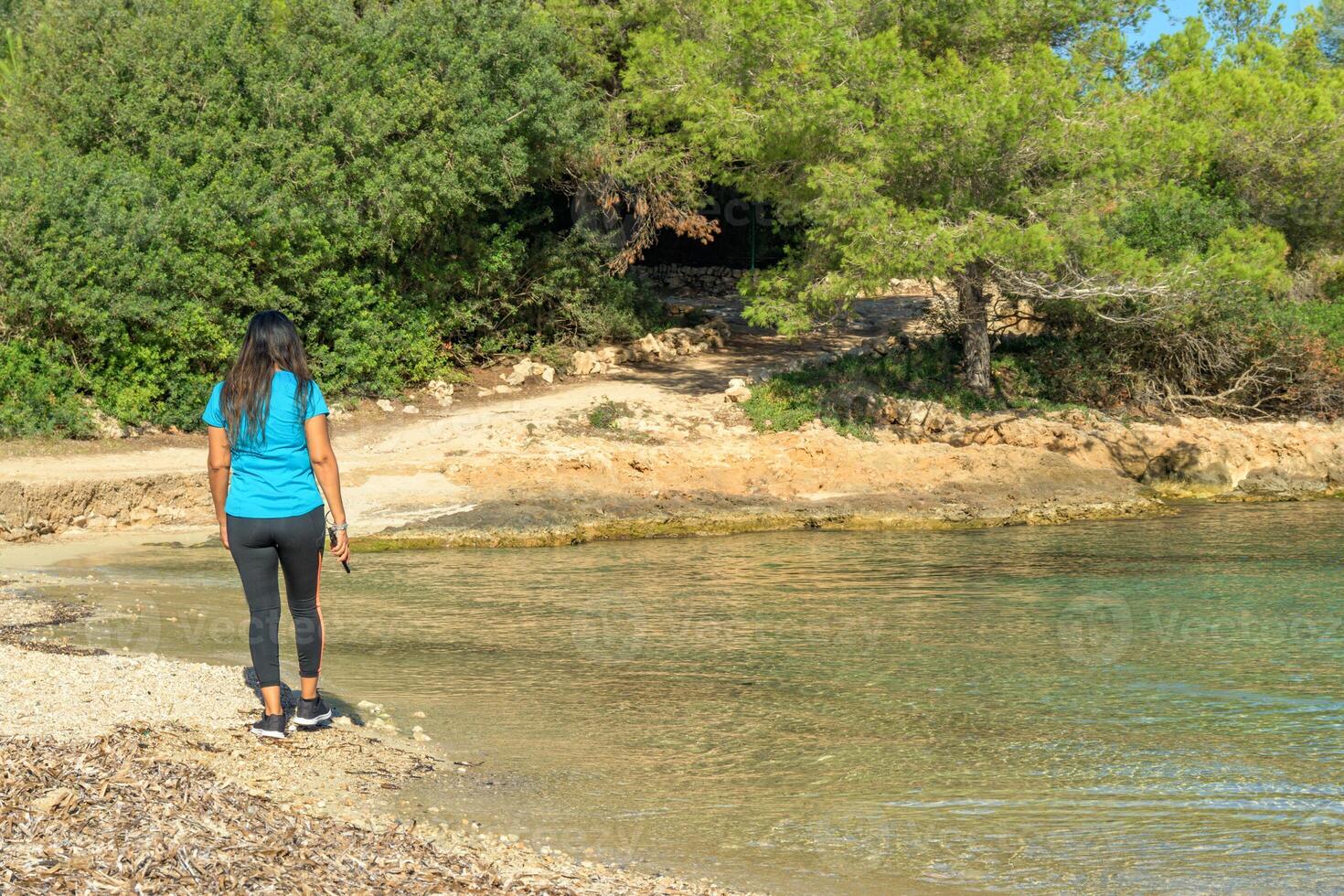 latina femme dans tenue de sport en marchant le long de le plage photo