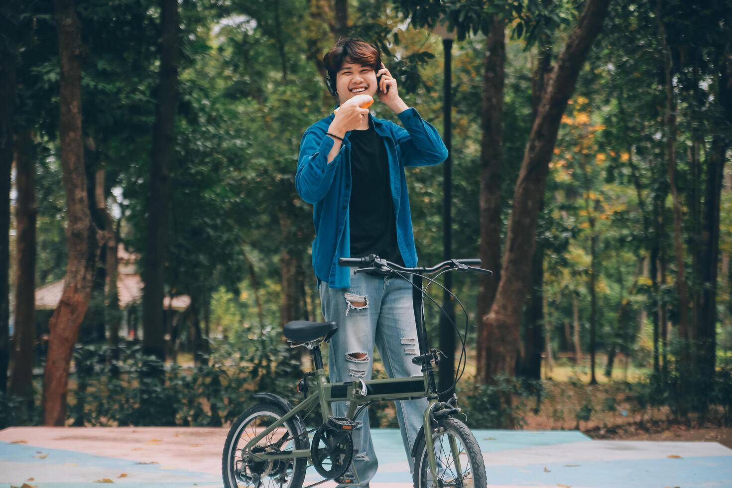 Jeune Beau barbu homme prise une Pause tandis que en voyageant le ville avec le sien vélo en utilisant le sien numérique tablette à la recherche une façon pensivement photo