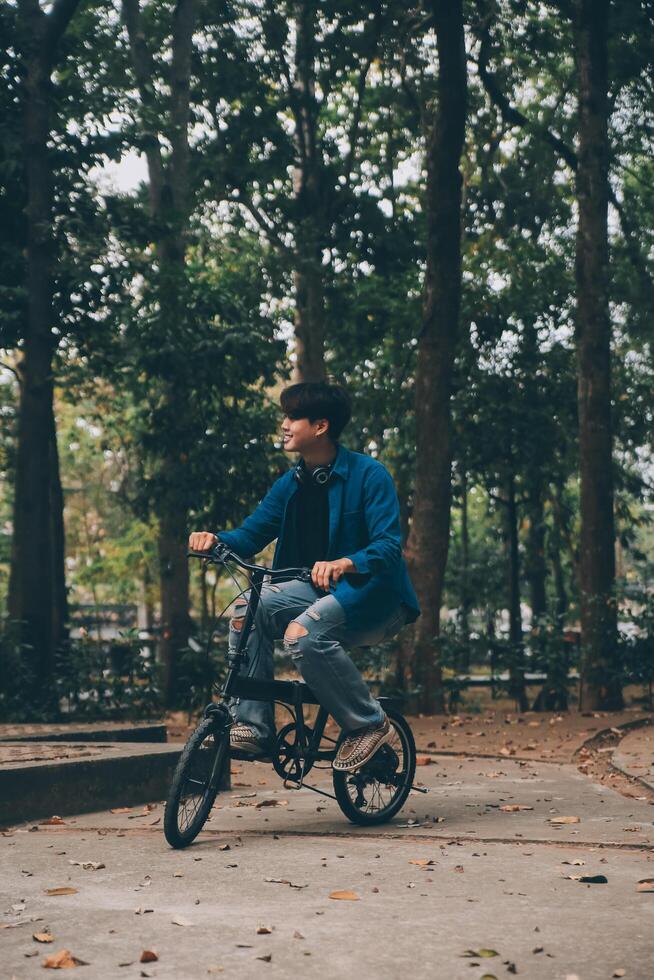 Jeune Beau barbu homme prise une Pause tandis que en voyageant le ville avec le sien vélo en utilisant le sien numérique tablette à la recherche une façon pensivement photo