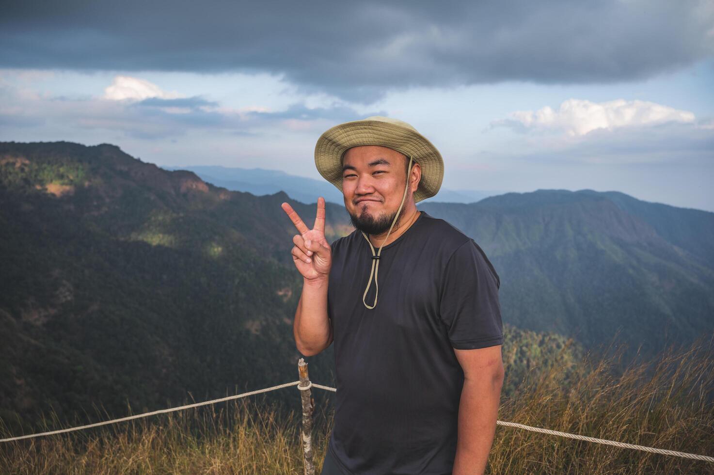 asiatique graisse homme avec magnifique vue de Khao san non wua Montagne kanchanaburi.khao san non wua est le le plus élevé Montagne dans Khao laem nationale parc. il est 1767 mètres au dessus mer niveau. photo