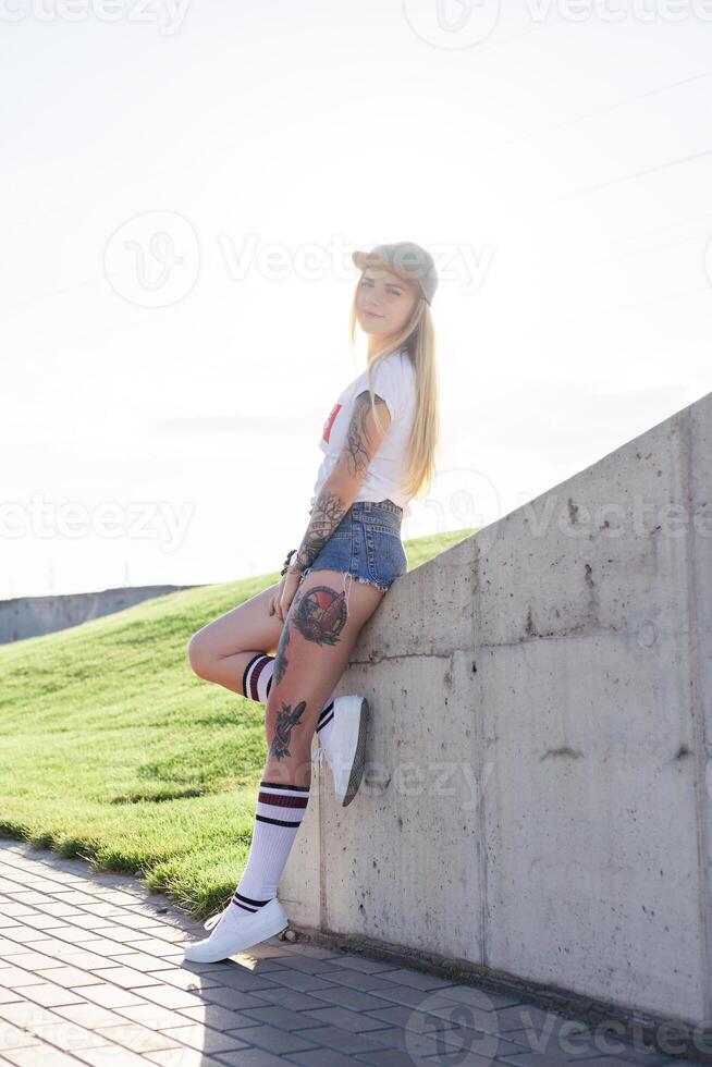 portrait de une branché Jeune fille souriant avec une longboard à le coucher du soleil. photo