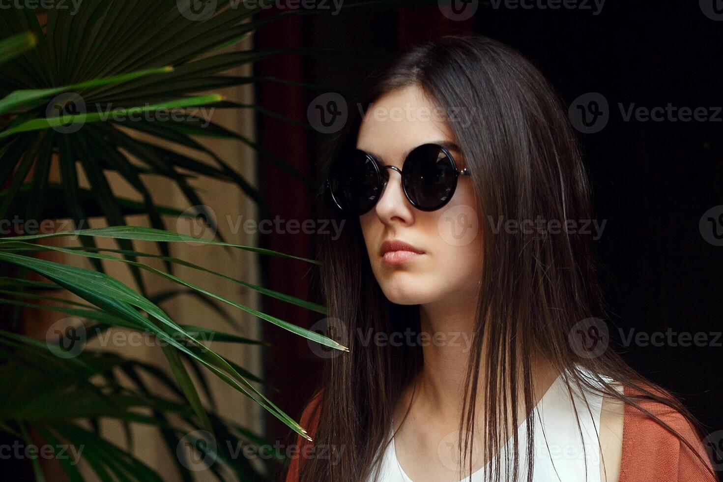 proche en haut portrait Jeune fille dans blanc chemise jeans et des lunettes de soleil photo