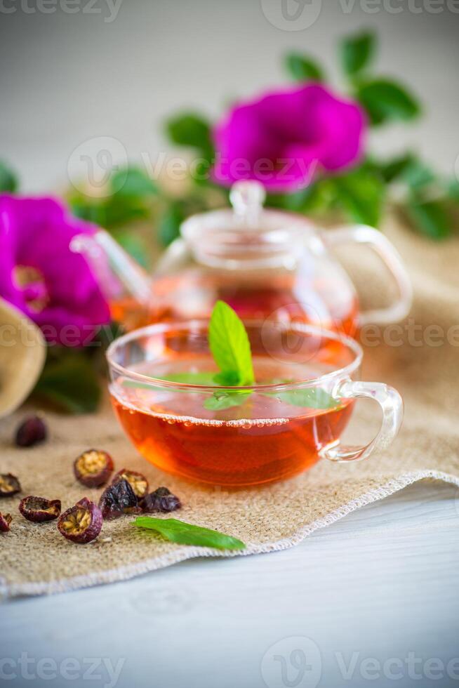 brassée rose musquée thé dans une verre théière avec rose musquée fleurs et menthe photo