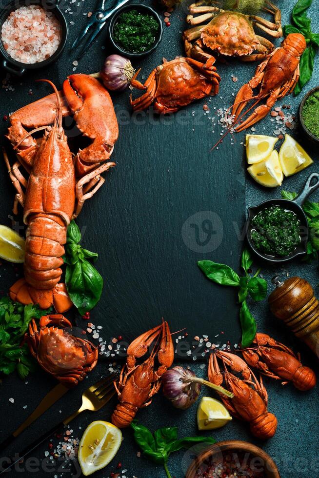 homard. bannière, gratuit espace pour texte. grillé homard, Crabe et écrevisse avec citron et basilic sur une noir ardoise planche. photo