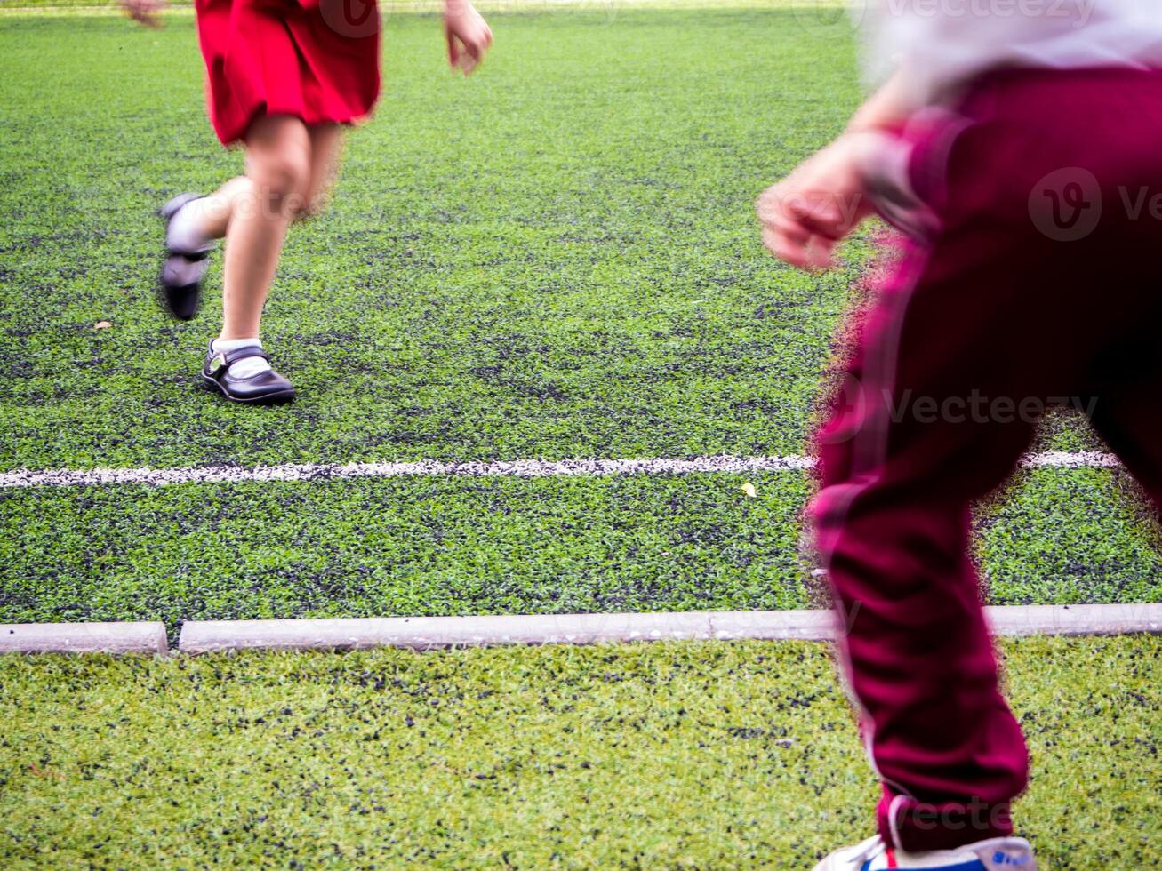 les enfants jouent sur le gazon artificiel de l'école photo