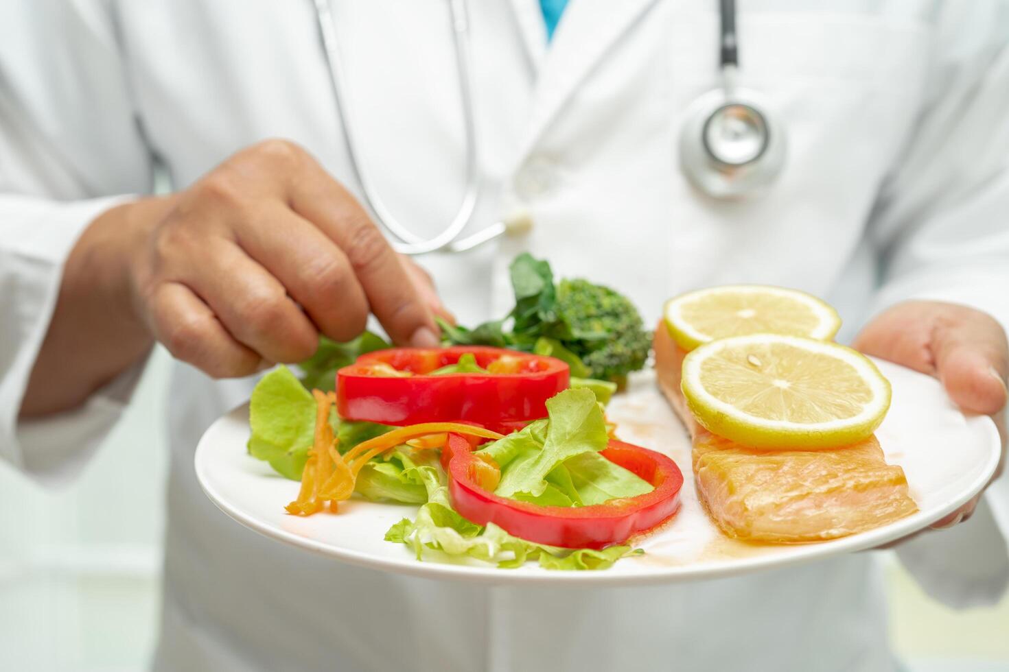 nutritionniste médecin en portant en bonne santé Saumon steak et légume vitamine nourriture pour patient dans hôpital. photo