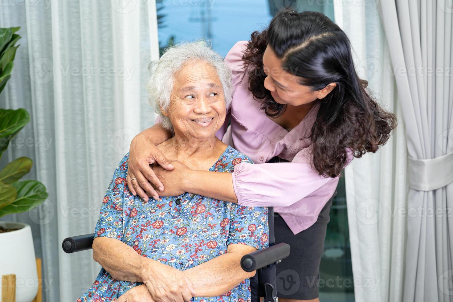 soignant Aidez-moi asiatique Sénior femme sur fauteuil roulant avec l'amour à maison. photo