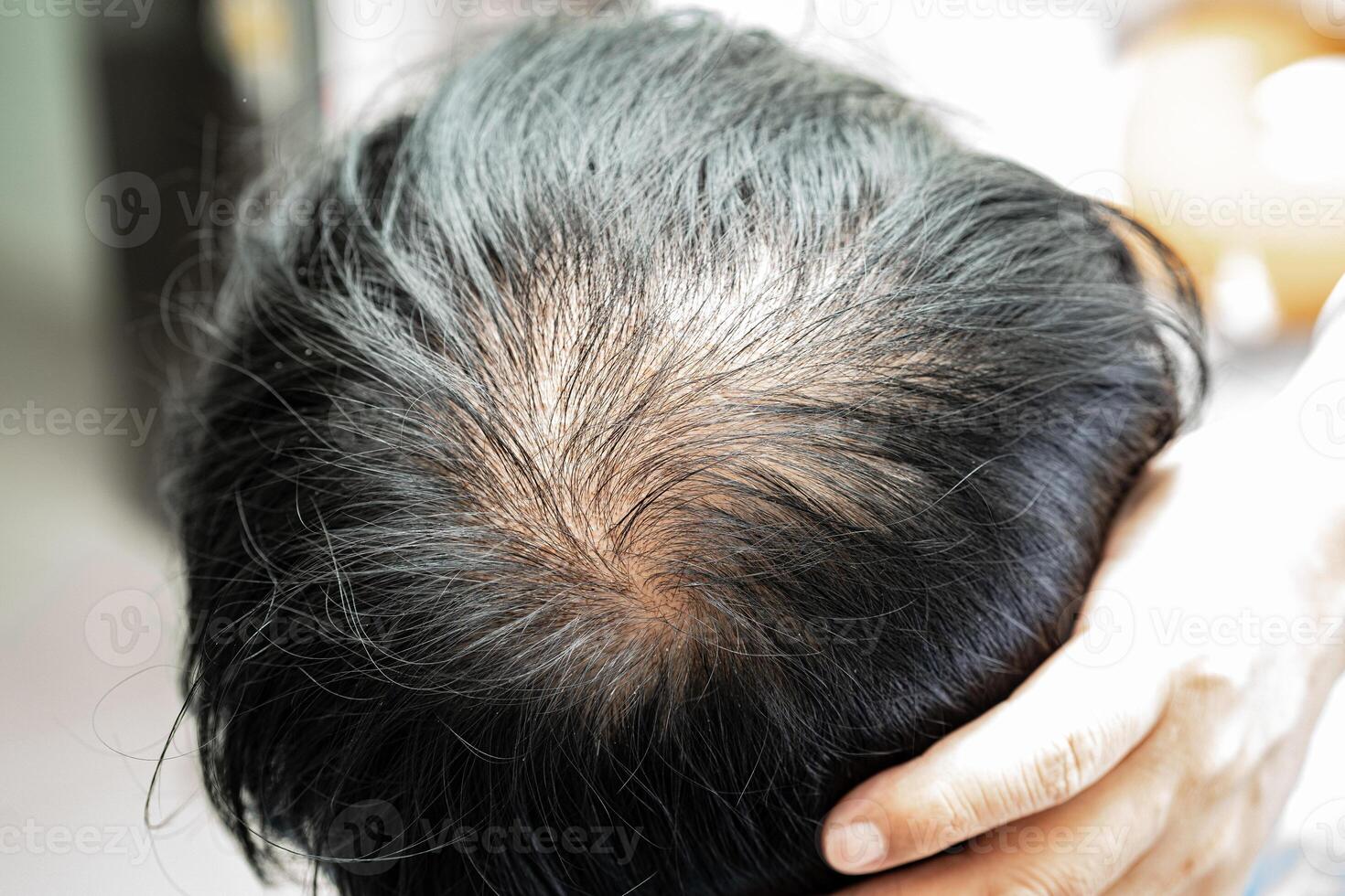 chauve au milieu de la tête et ne commence pas à perdre les cheveux glabres d'un homme de bureau actif et intelligent d'affaires asiatiques matures. photo