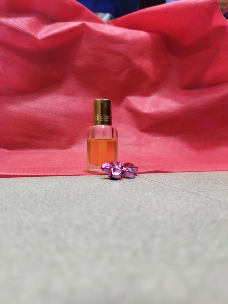 une petit bouteille de parfum séance sur une rouge tissu photo