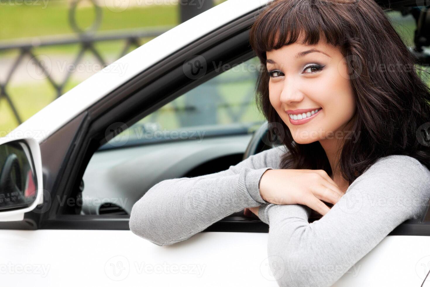 Jeune chauffeur femme dans blanc voiture photo