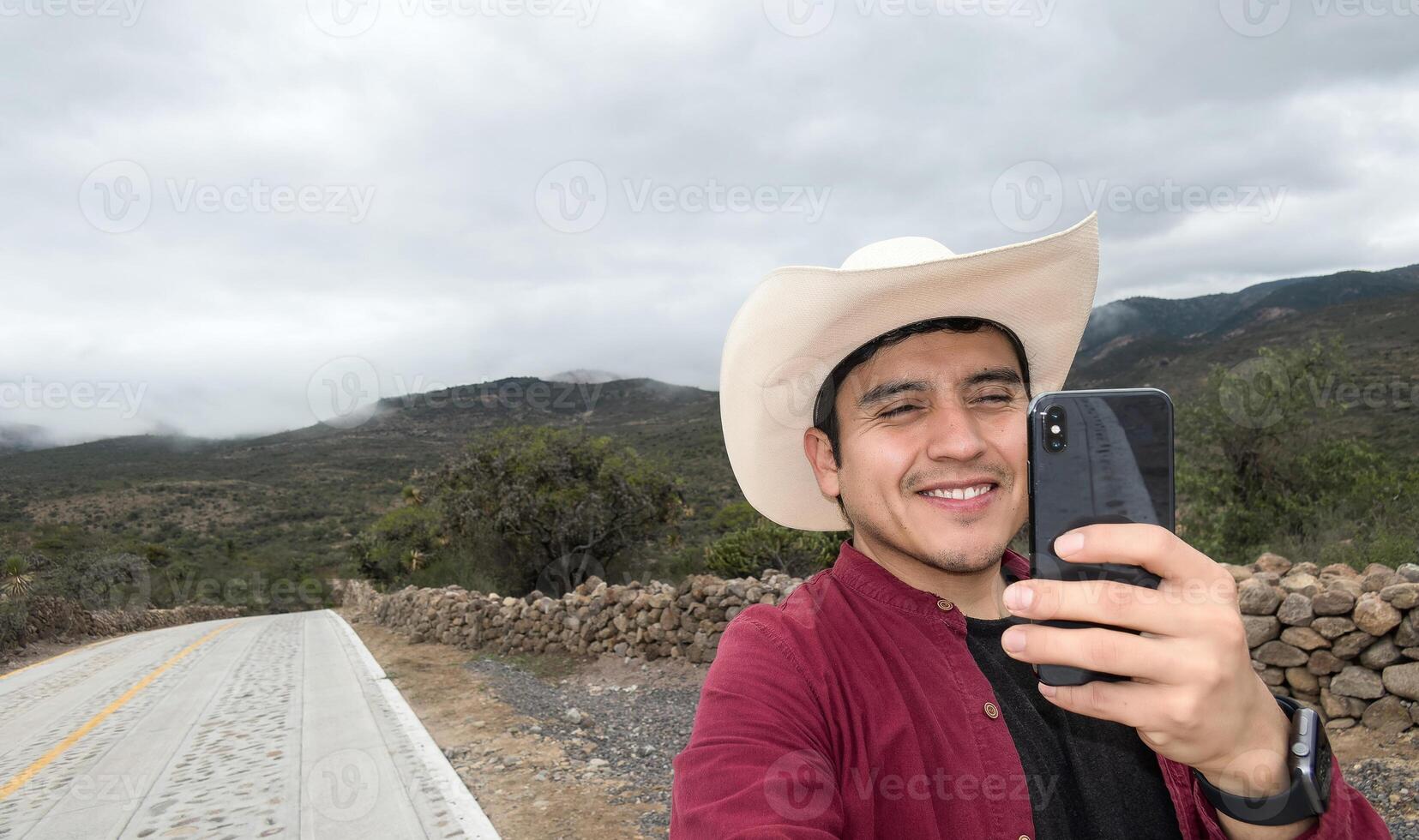 homme dans chapeau fabrication vidéo appel avec le sien téléphone dans zone avec pauvres signal, avec espace pour texte photo