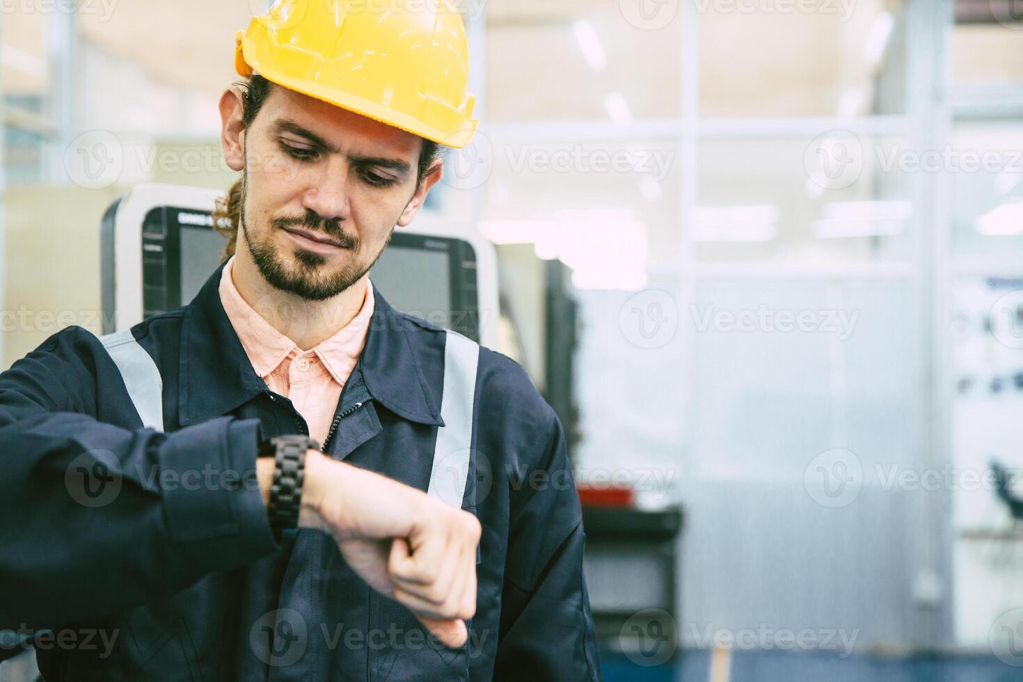 ingénieur ouvrier à la recherche à montre-bracelet. industrie usine travail heures après midi Pause fois pour le déjeuner photo