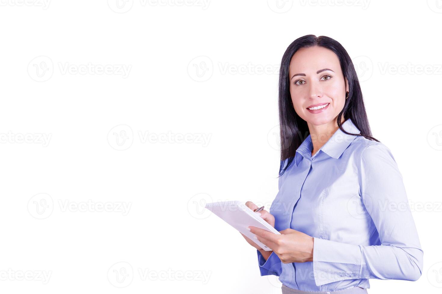 portrait de une souriant, Jeune attrayant affaires femme dans une bleu chemise avec une bloc-notes dans sa mains. affaires Dame photo