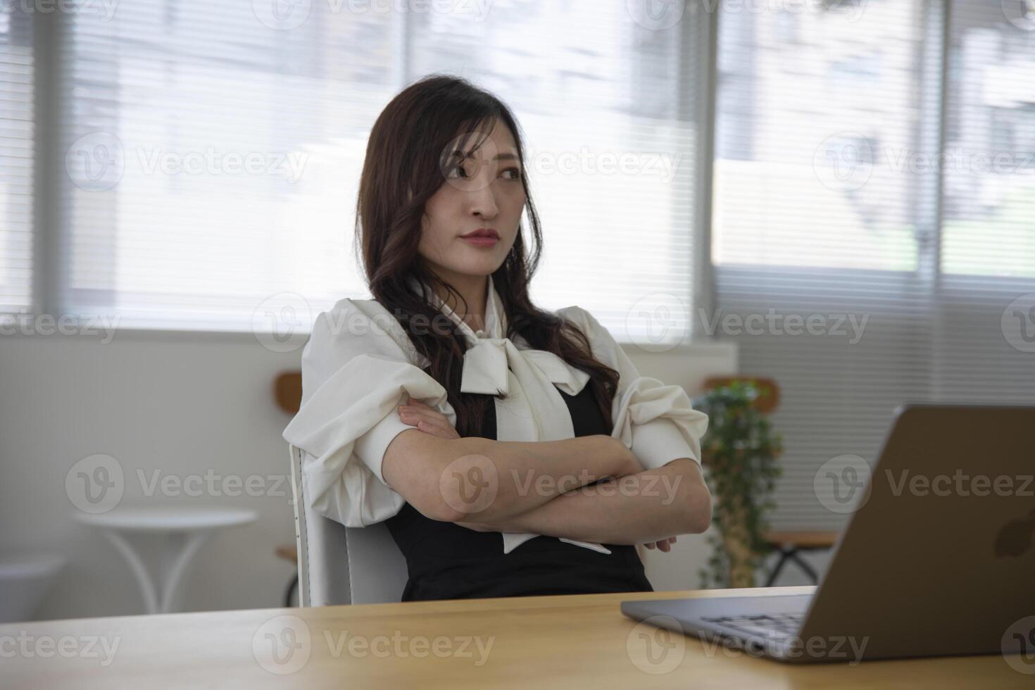 une inquiet Japonais femme par éloigné travail dans le petit Bureau photo