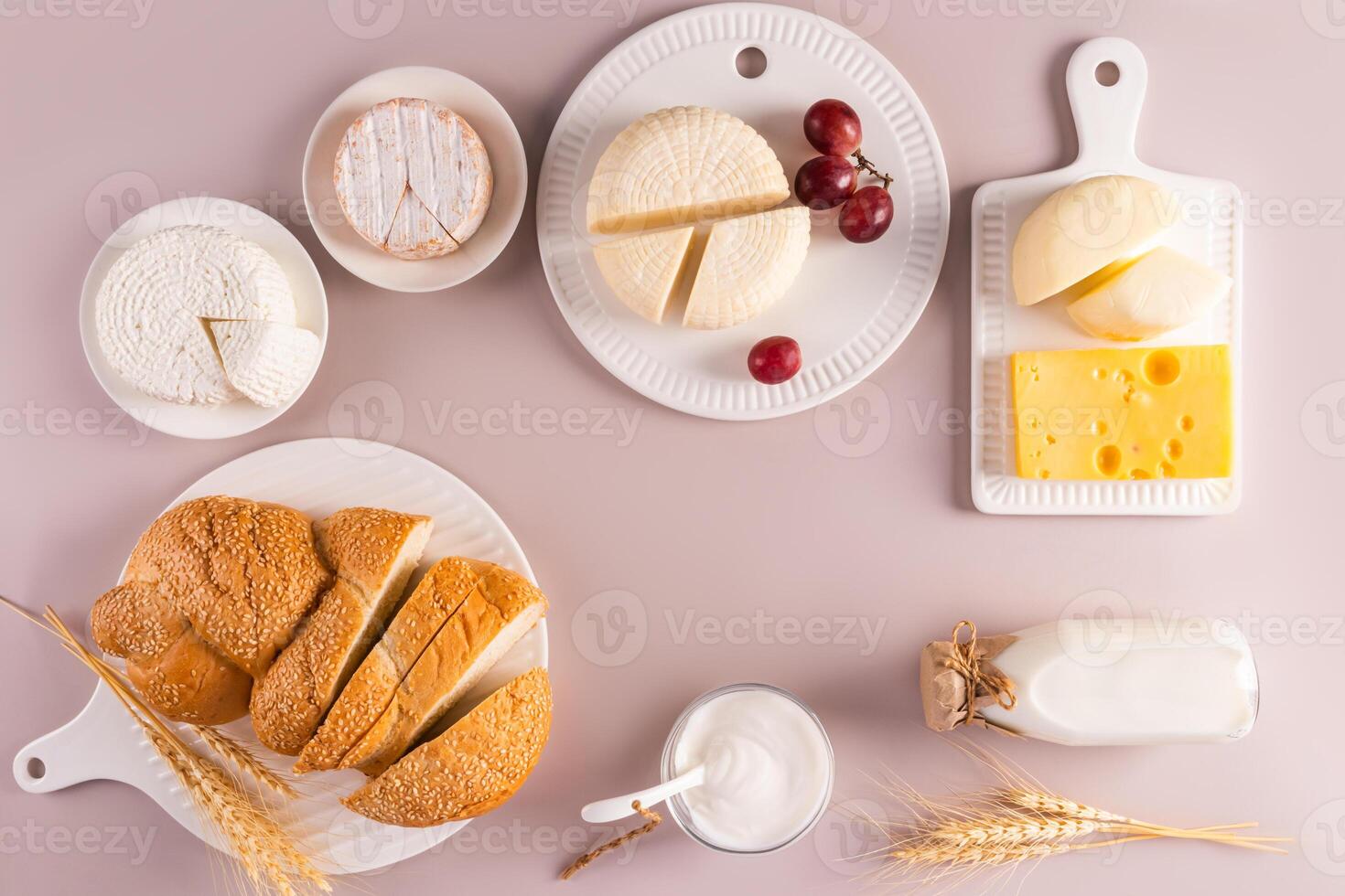 magnifique de fête Contexte pour le vacances de juif chavouot. plat disposition de laitier des produits, pain sur blanc céramique plateaux. Haut voir. photo