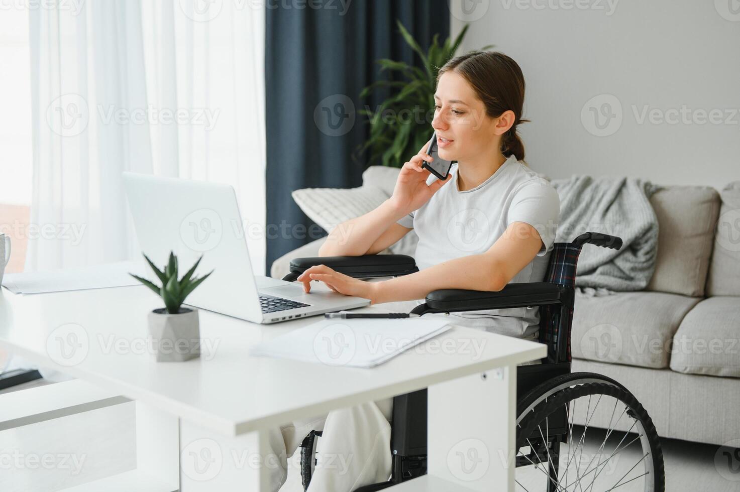 femme dans une fauteuil roulant travaux sur le portable PC dans le Accueil Bureau avec un assistance chien comme une un compagnon photo