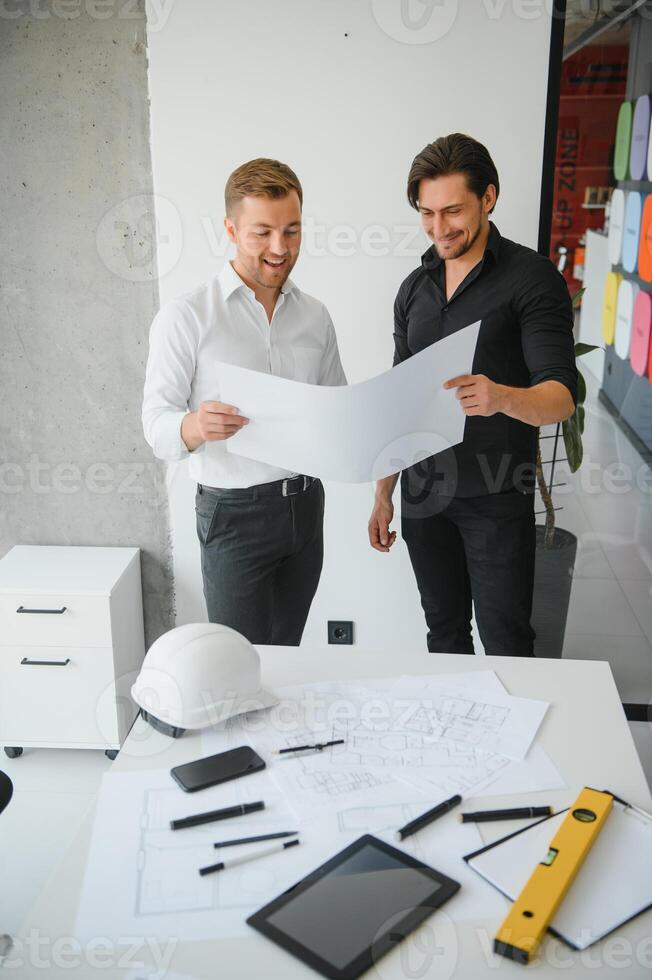ingénieur ou architecte travail en équipe travail sur construction projet avec bâtiment modèle et plan dans bureau. construction concept. photo