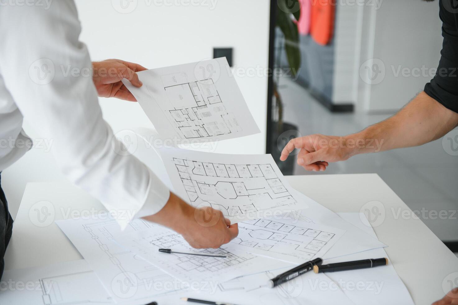 ingénieur ou architecte travail en équipe travail sur construction projet avec bâtiment modèle et plan dans bureau. construction concept. photo