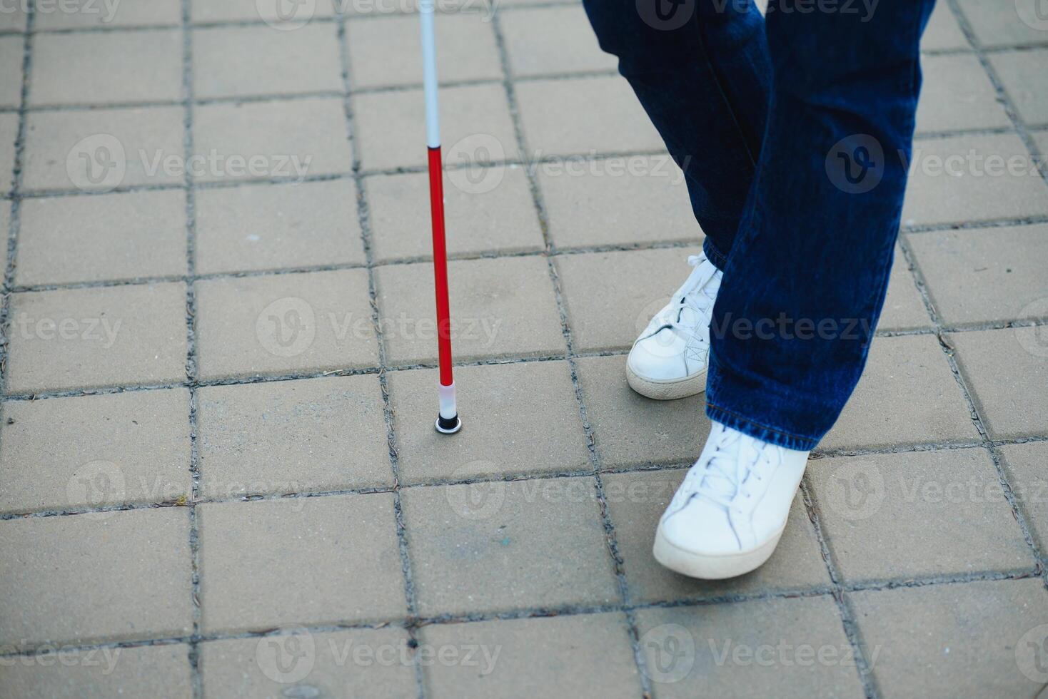 fermer de une aveugle homme permanent avec blanc bâton sur rue photo