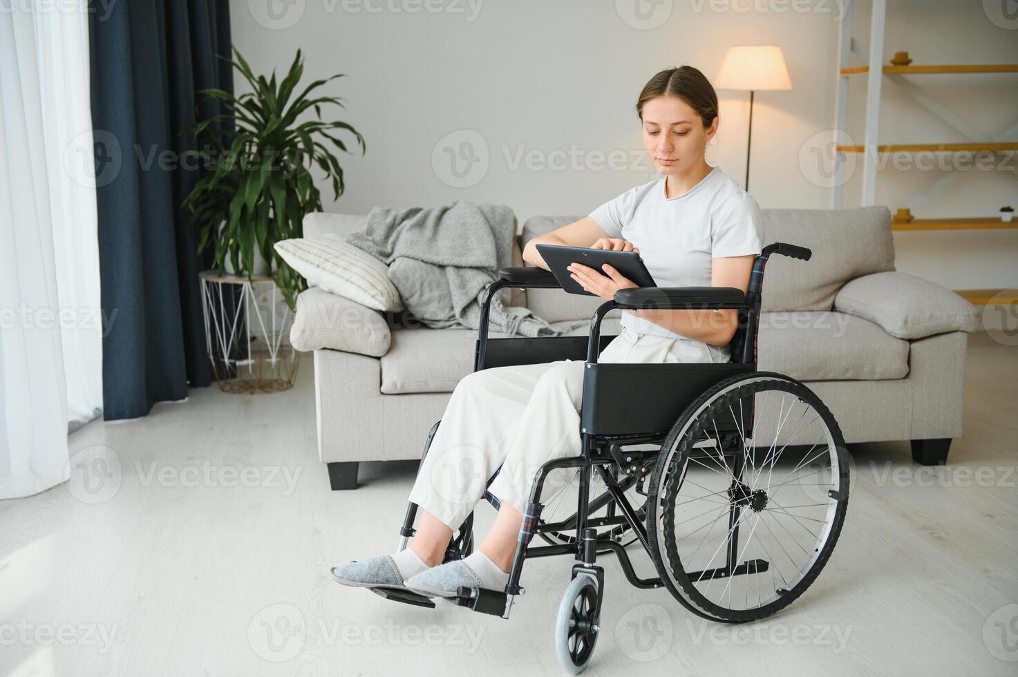femme asseoir dans fauteuil roulant tenir tablette parler avec Jeune femme médecin en utilisant sans fil l'Internet connexion, handicapé mature vieux Dame parler consulter avec médical spécialiste sur tampon. photo
