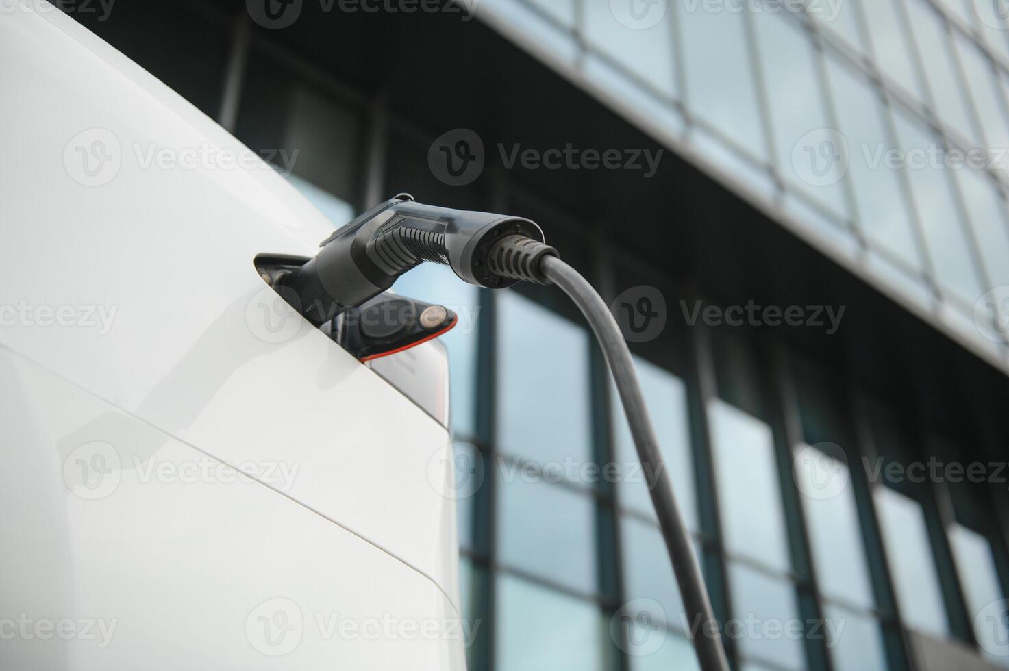 proche en haut de le hybride voiture électrique chargeur station avec Puissance la fourniture branché dans un électrique voiture étant accusé. photo