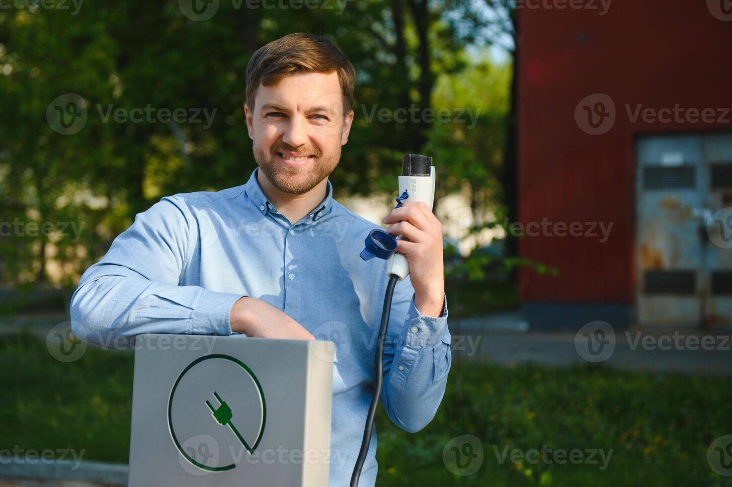 homme en portant Puissance mise en charge câble pour électrique auto. photo