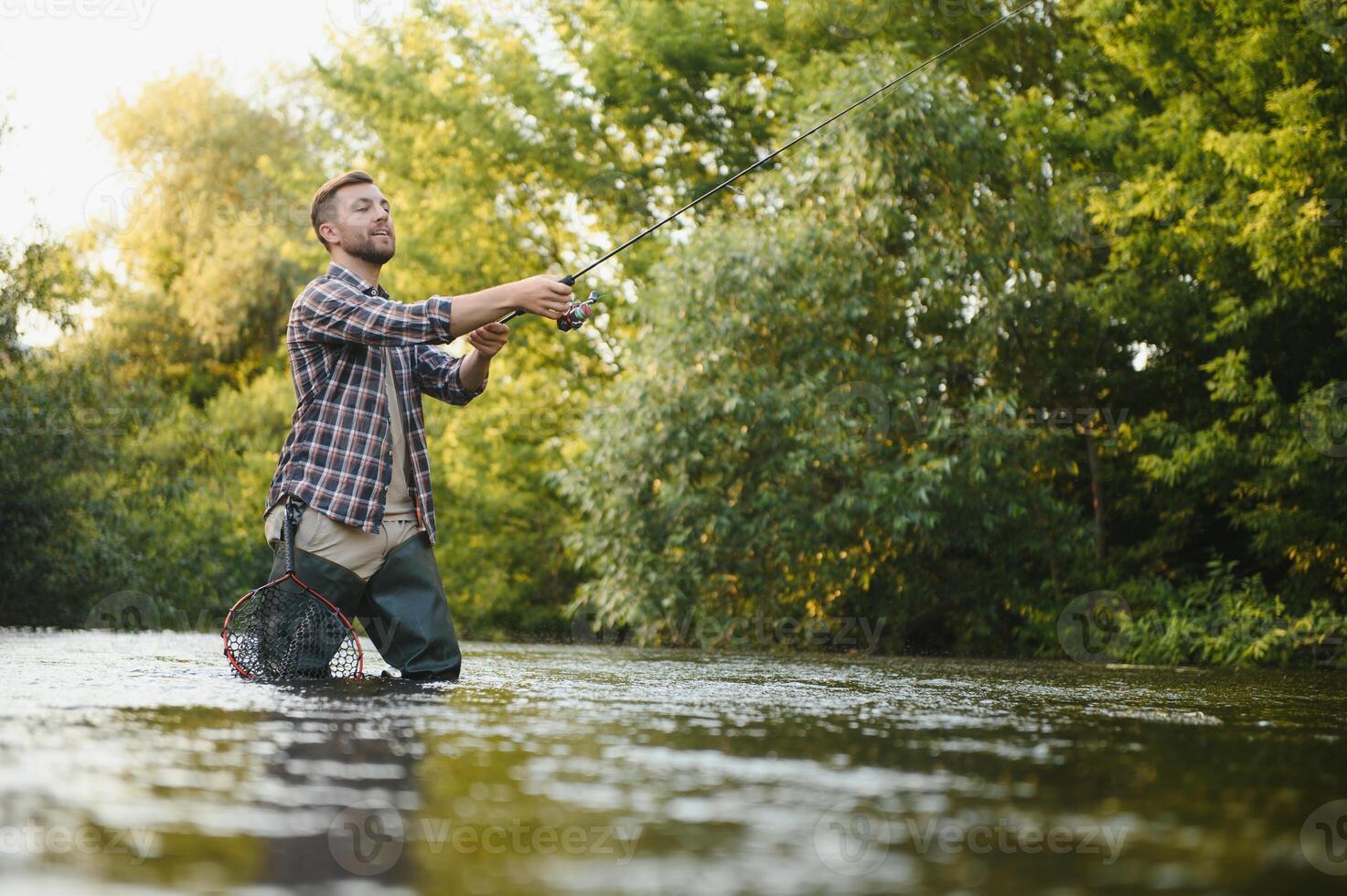 Jeune homme pêche à la mouche à lever du soleil photo