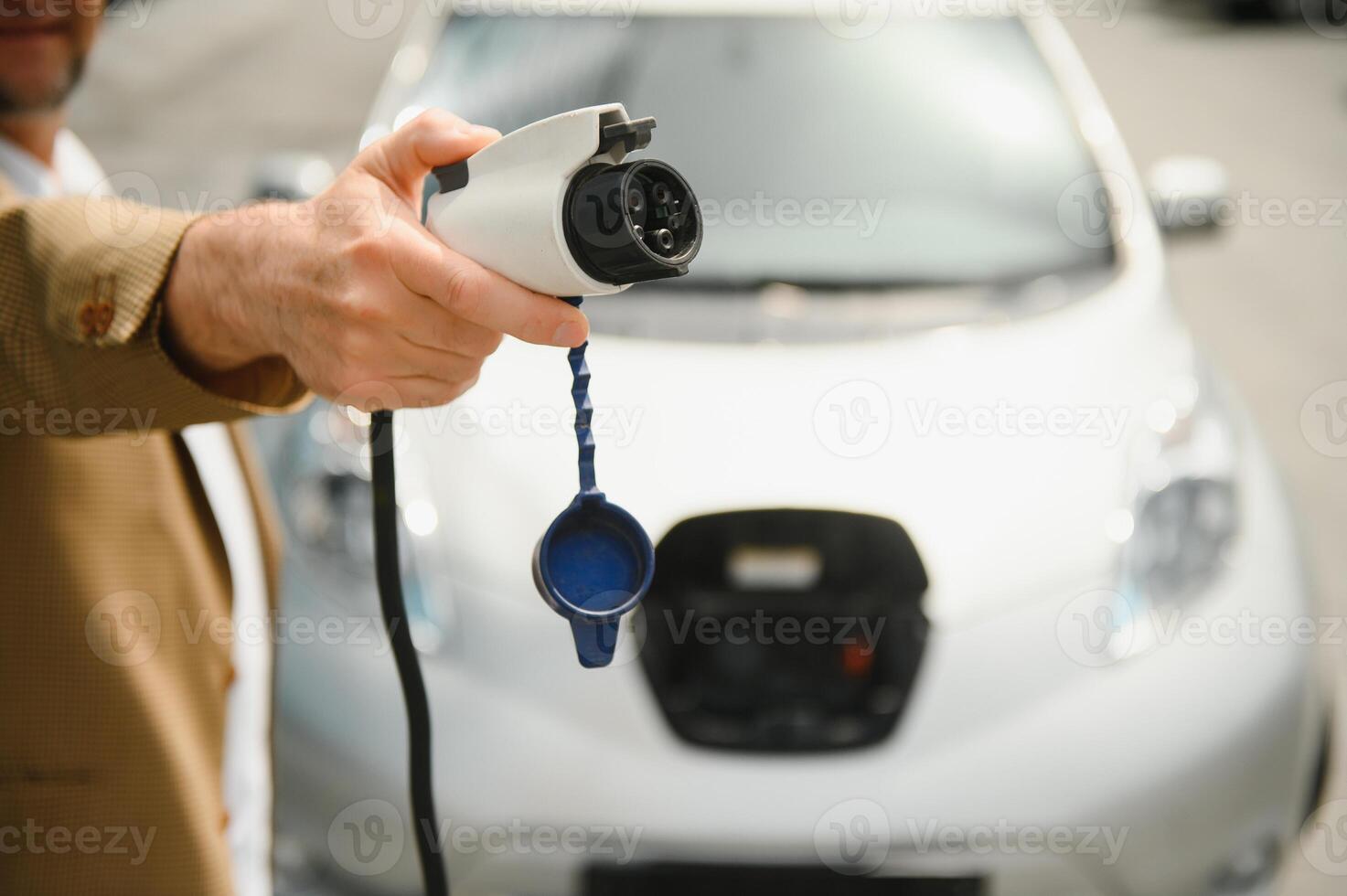 homme des charges un électrique voiture à le mise en charge station photo