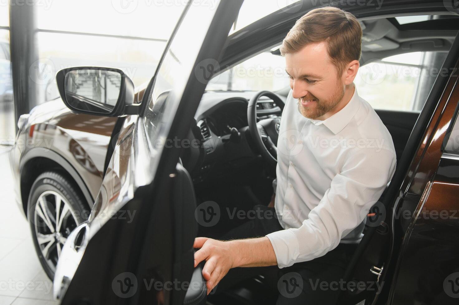 homme adulte client Masculin acheteur client choisit auto veut à acheter Nouveau voiture toucher vérifier voiture dans salle d'exposition véhicule salon concession boutique moteur spectacle intérieur. Ventes concept photo