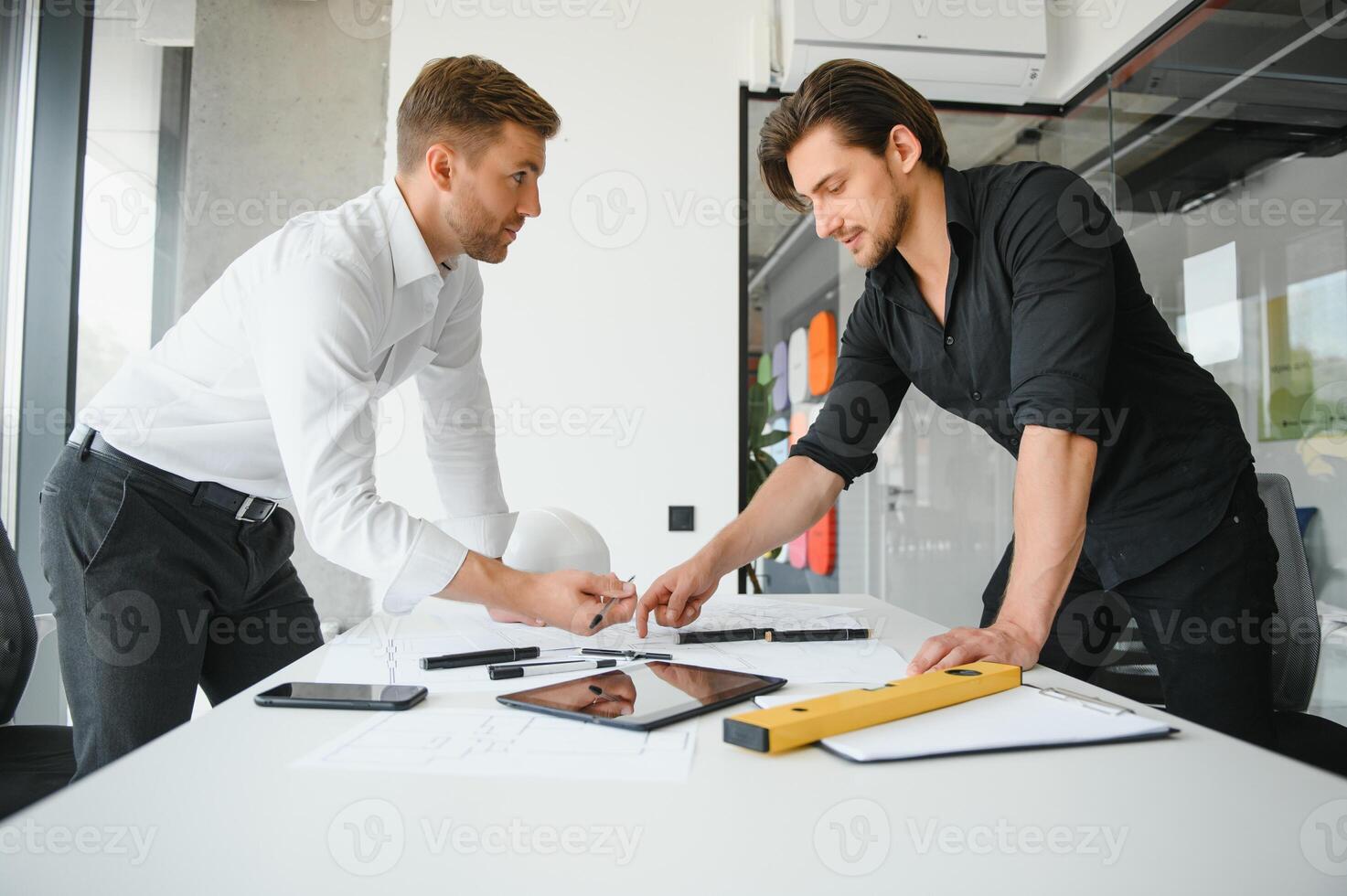 ingénieur ou architecte travail en équipe travail sur construction projet avec bâtiment modèle et plan dans bureau. construction concept. photo