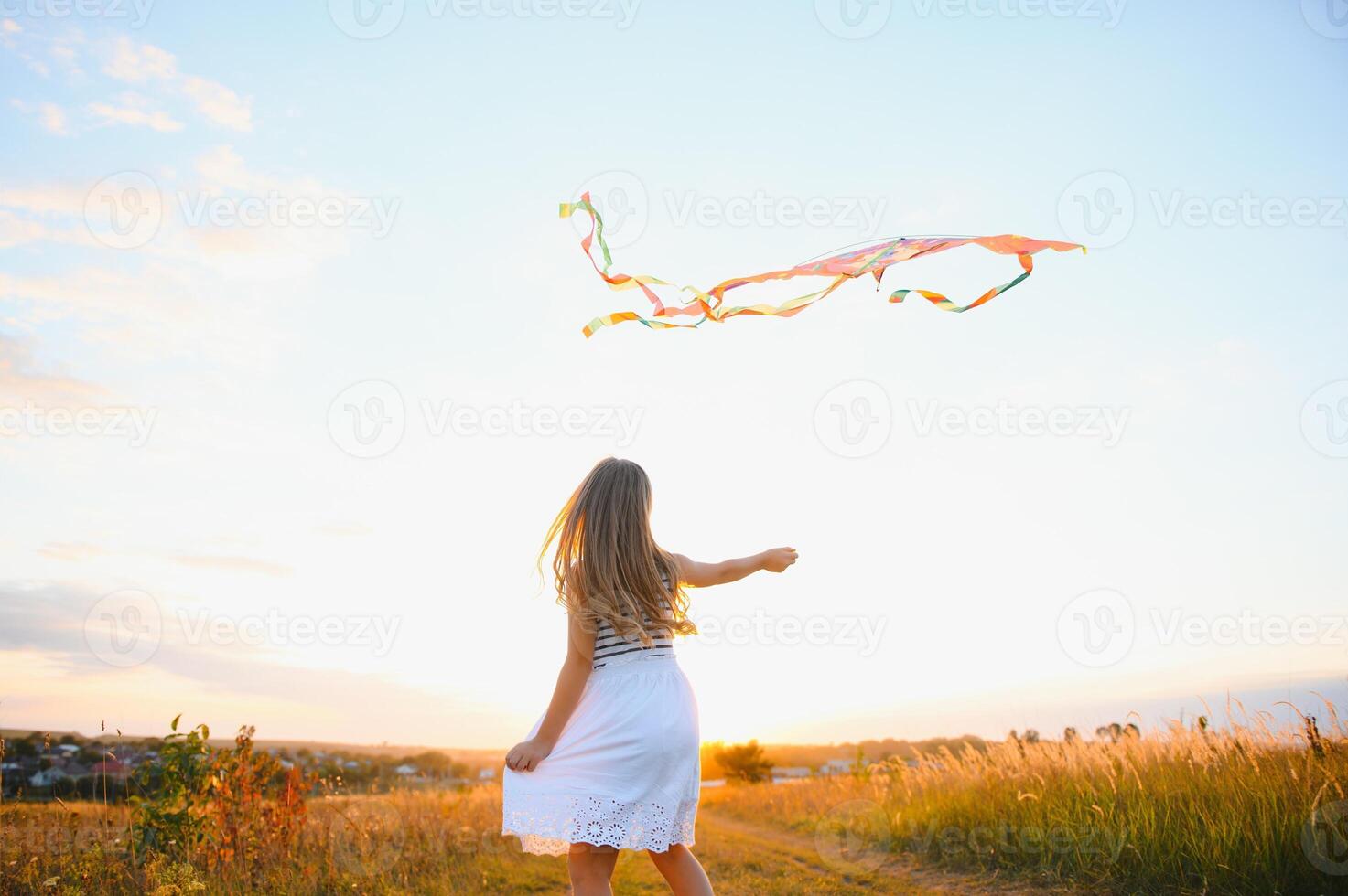 peu mignonne sept ans vieux fille fonctionnement dans le champ avec cerf-volant sur été journée photo