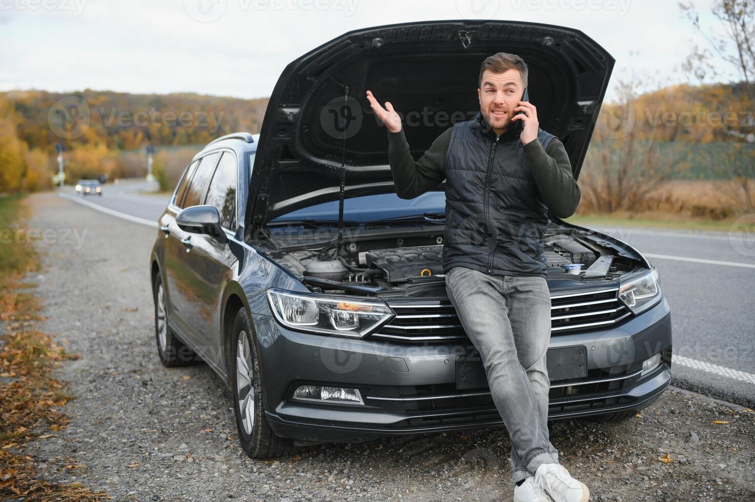 le voiture cassé bas, fume de en dessous de le capot, le chauffeur sous le choc photo