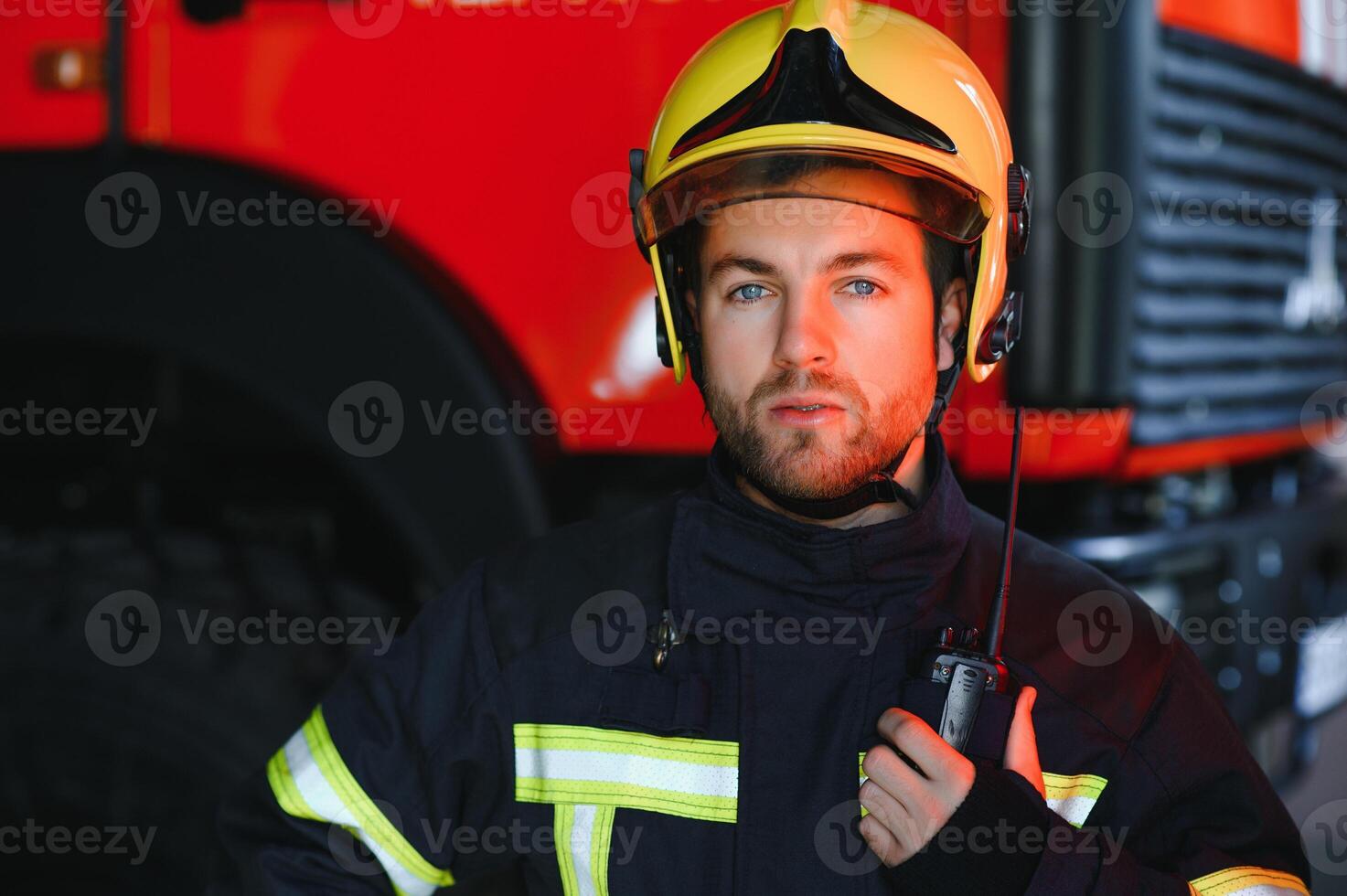 sur de soi pompier portant protecteur uniforme permanent suivant à une Feu moteur dans une garage de une Feu département photo