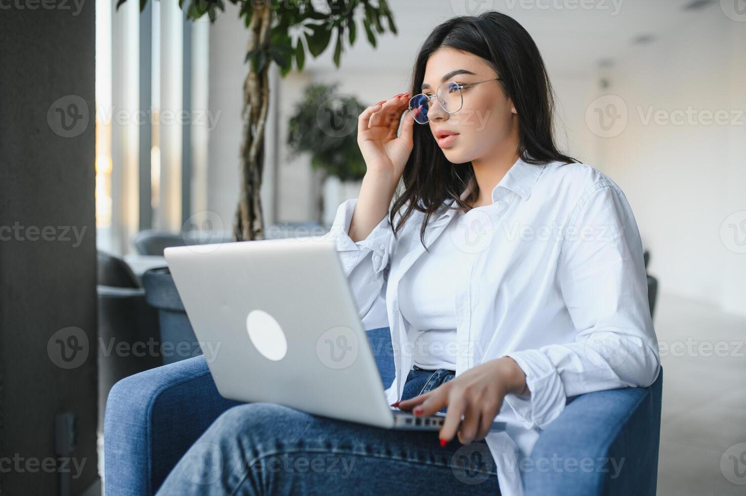 magnifique Jeune pigiste femme en utilisant portable ordinateur séance à café tableau. content souriant fille travail en ligne ou en train d'étudier et apprentissage tandis que en utilisant carnet. free-lance travail, affaires gens concept. photo