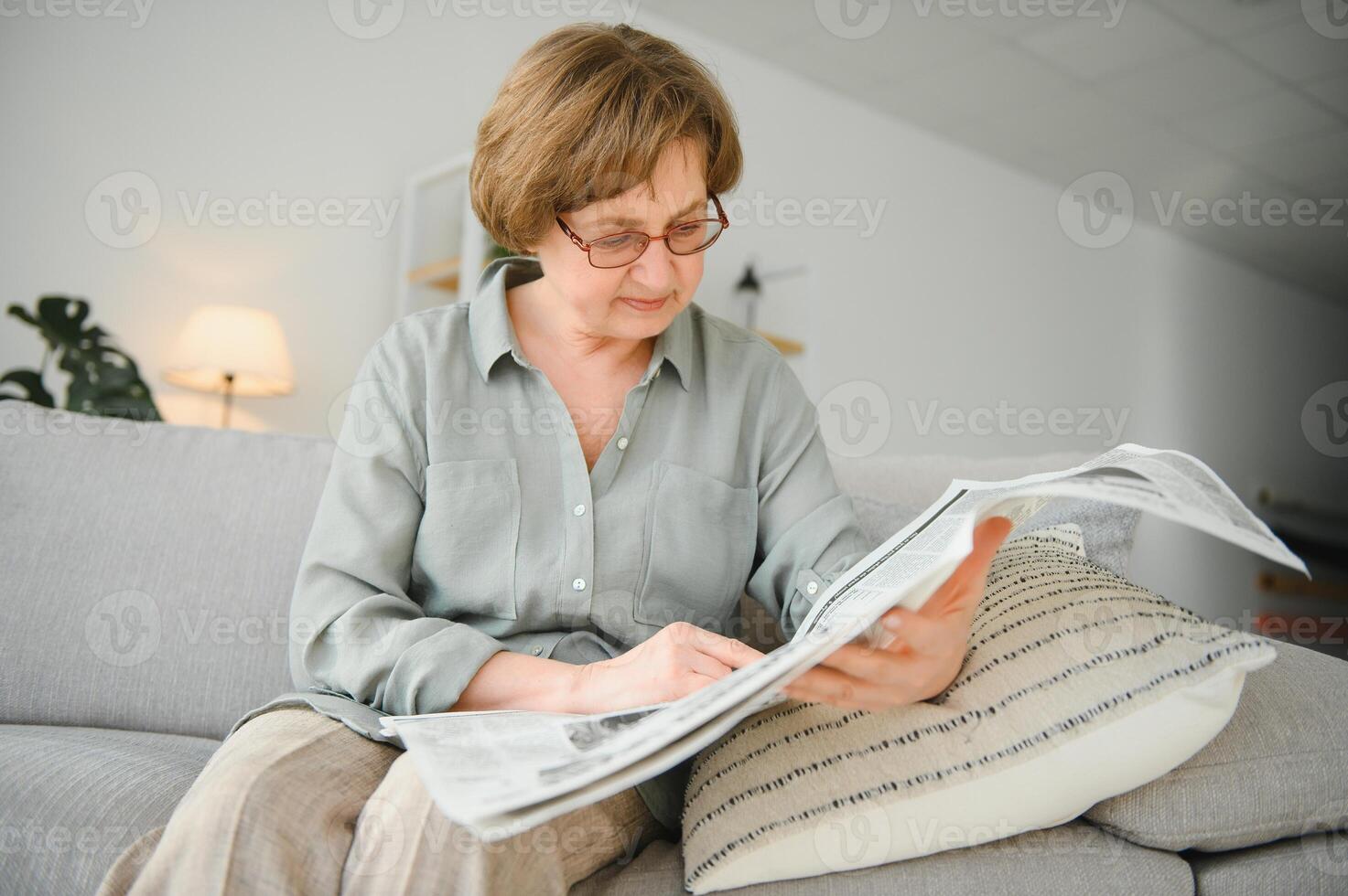 femme dans chambre avec journal souriant photo