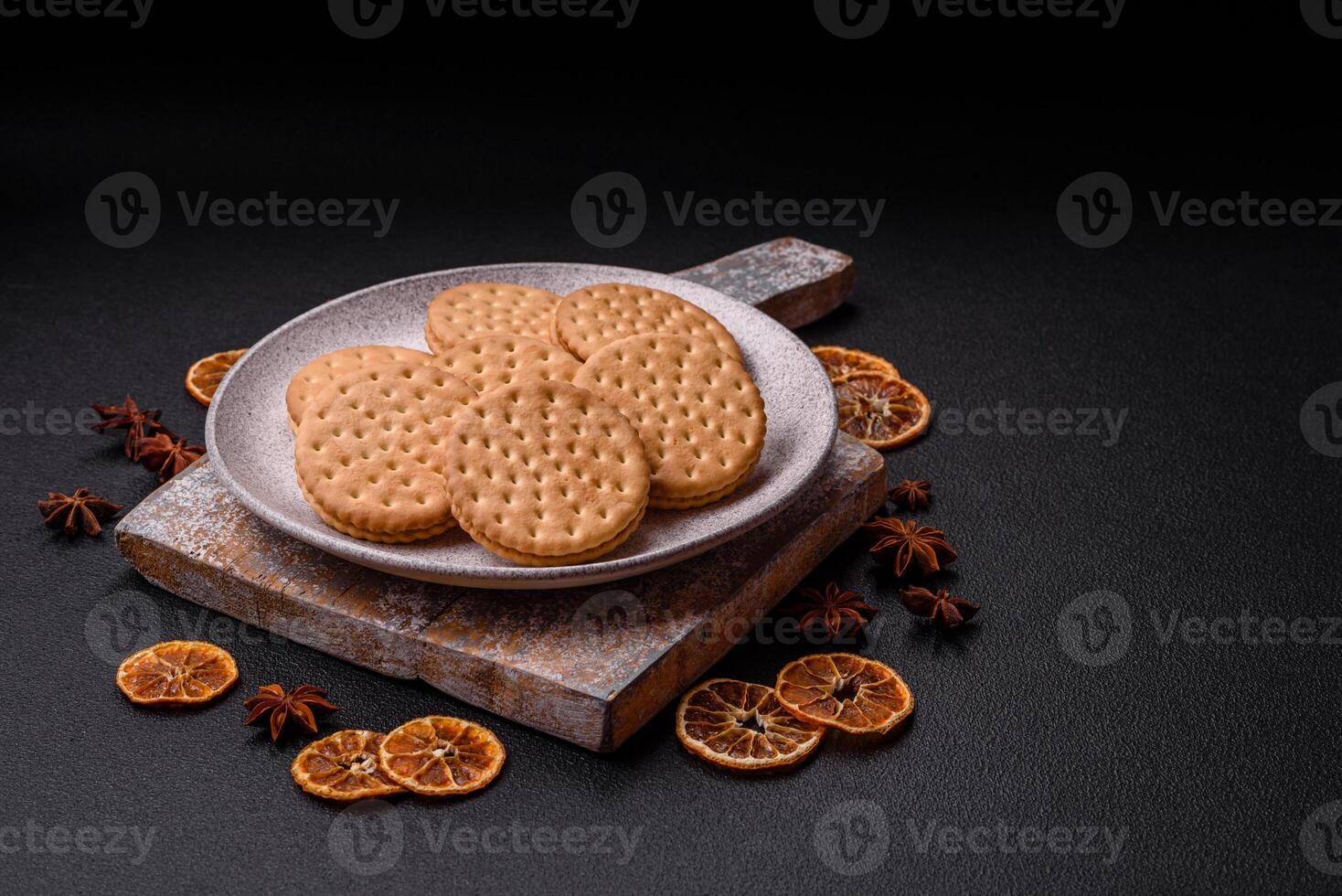 rond à pois casse-croûte casse-croûte biscuits avec crème sur une foncé béton Contexte photo