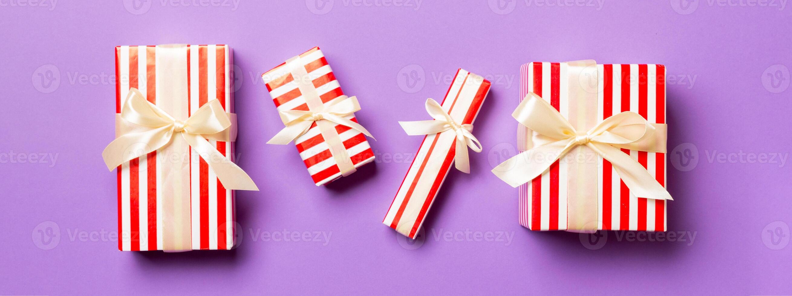 enveloppé Noël ou autre vacances Fait main présent dans papier avec Jaune ruban sur violet Contexte. présent boîte, décoration de cadeau sur coloré tableau, Haut vue photo