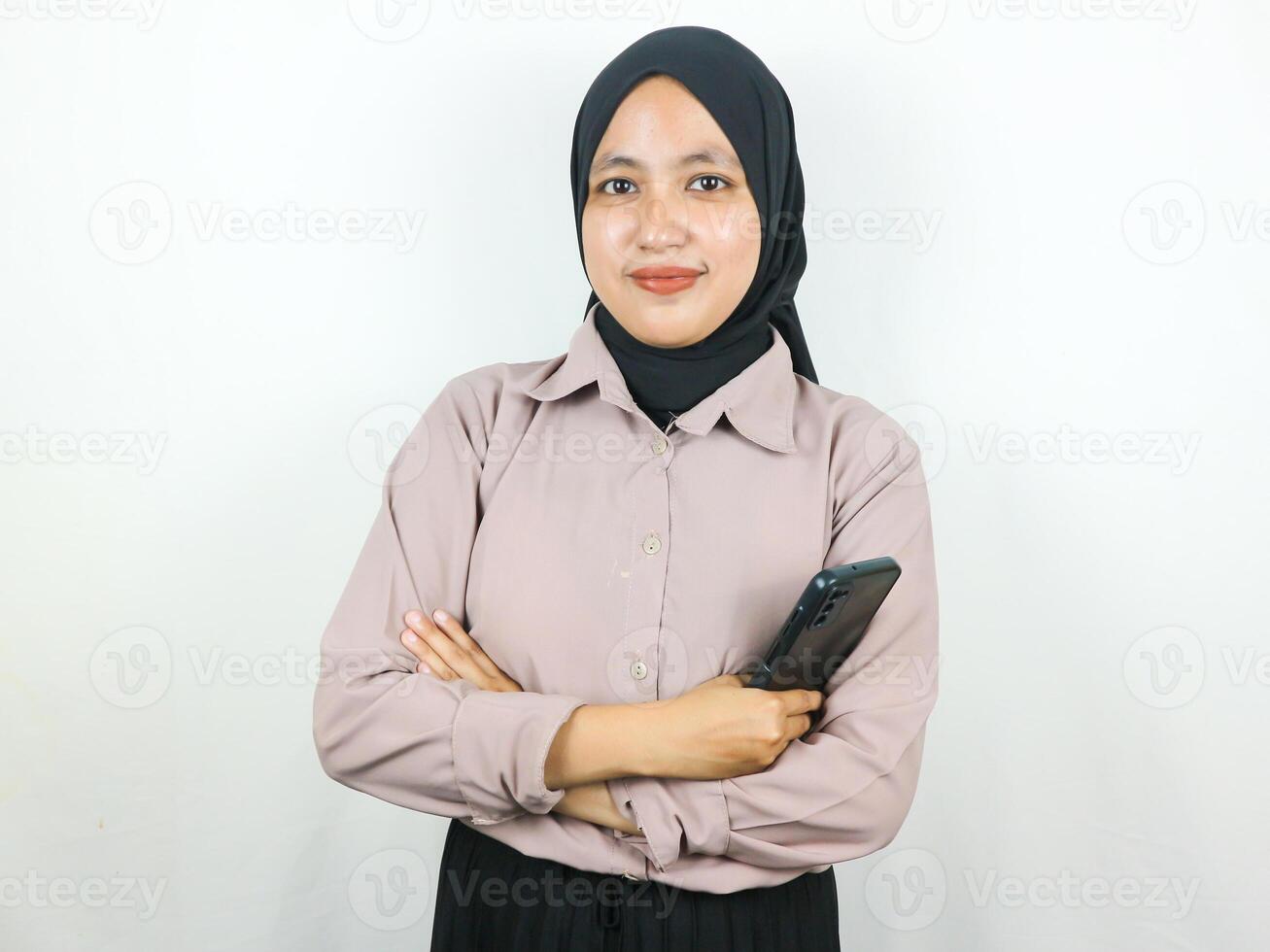 magnifique asiatique musulman femme souriant en toute confiance avec mains en portant intelligent téléphone. La publicité concept photo