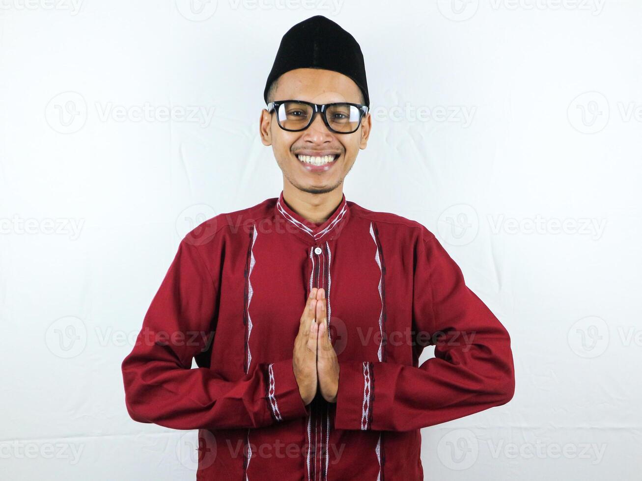 asiatique musulman homme portant des lunettes souriant à donner salutation pendant Ramadan et eid Al fitr fête plus de blanc Contexte photo