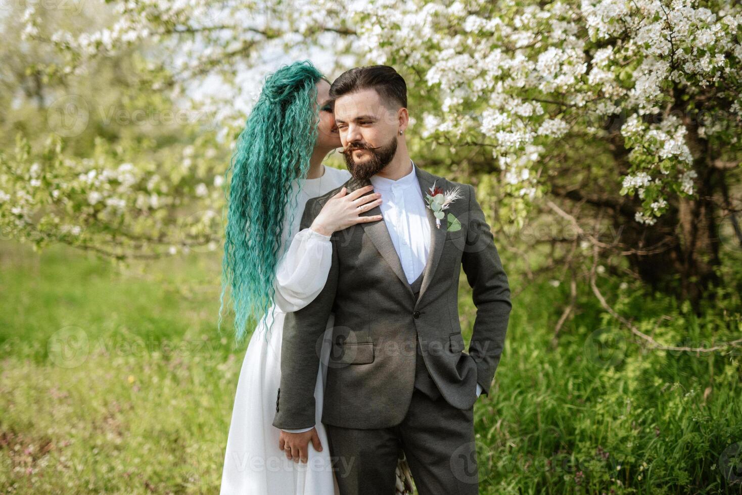 une barbu jeune marié et une fille avec vert cheveux sont en marchant photo