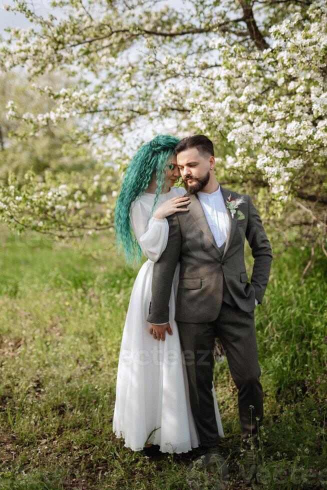 une barbu jeune marié et une fille avec vert cheveux sont en marchant photo