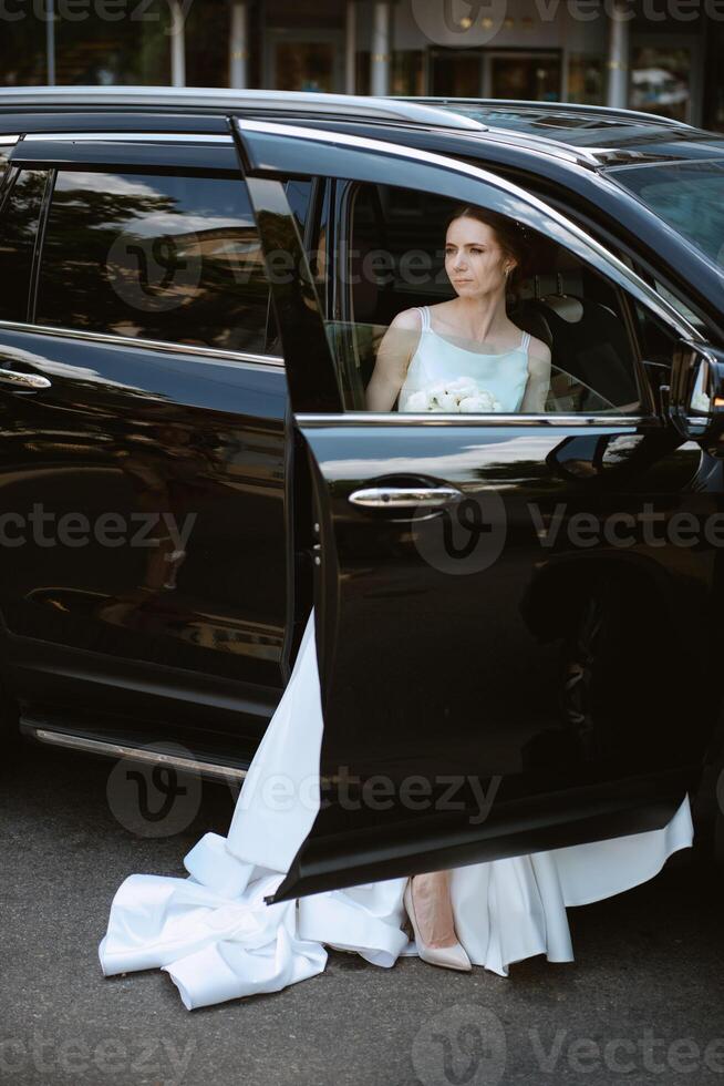 la mariée avec une noir voiture près une verre gratte-ciel photo