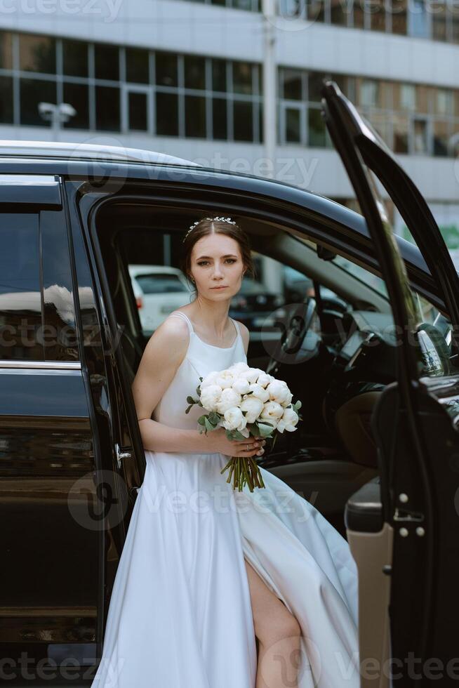 la mariée avec une noir voiture près une verre gratte-ciel photo